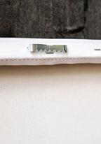 Close up of back of white canvas showing silver wall mount
