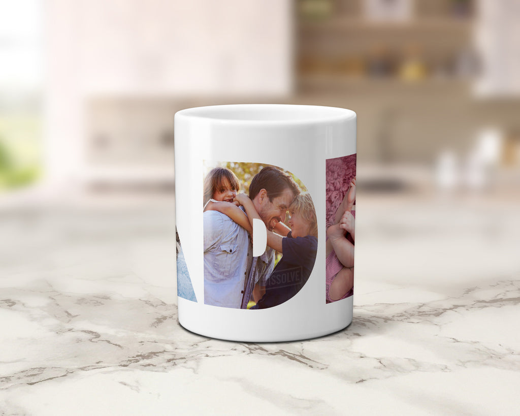 A white ceramic coffee mug with custom printed circular and rectangular family photos, displayed on a light marble countertop with a blurred kitchen background.