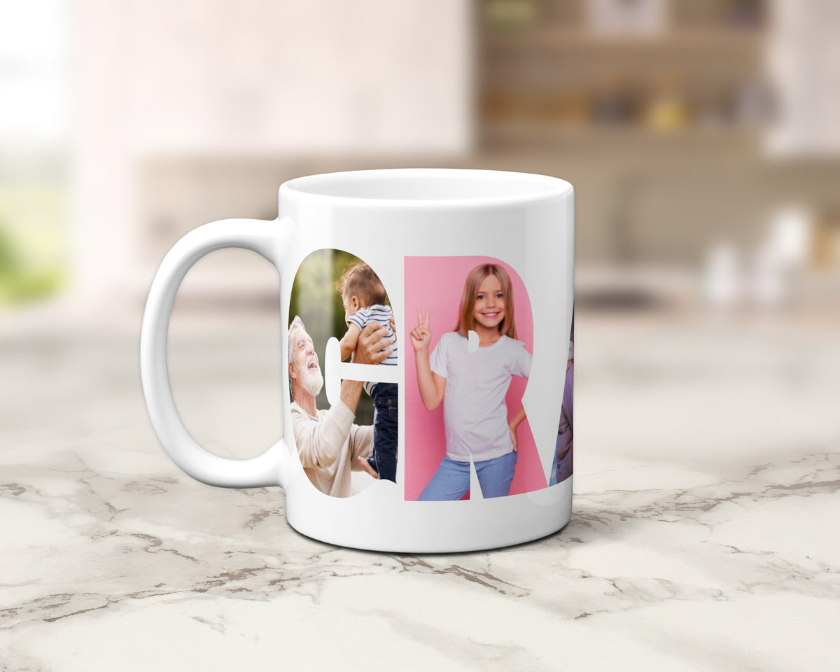 A white ceramic coffee mug with a custom photo collage within the letters spelling 'GRANDAD', set on a light marble countertop with a blurred kitchen background.