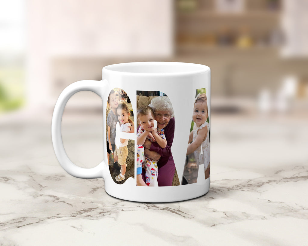 A white ceramic coffee mug with custom printed family photos in lettering spelling 'GRANDMA', set on a light marble countertop with a blurred kitchen background.