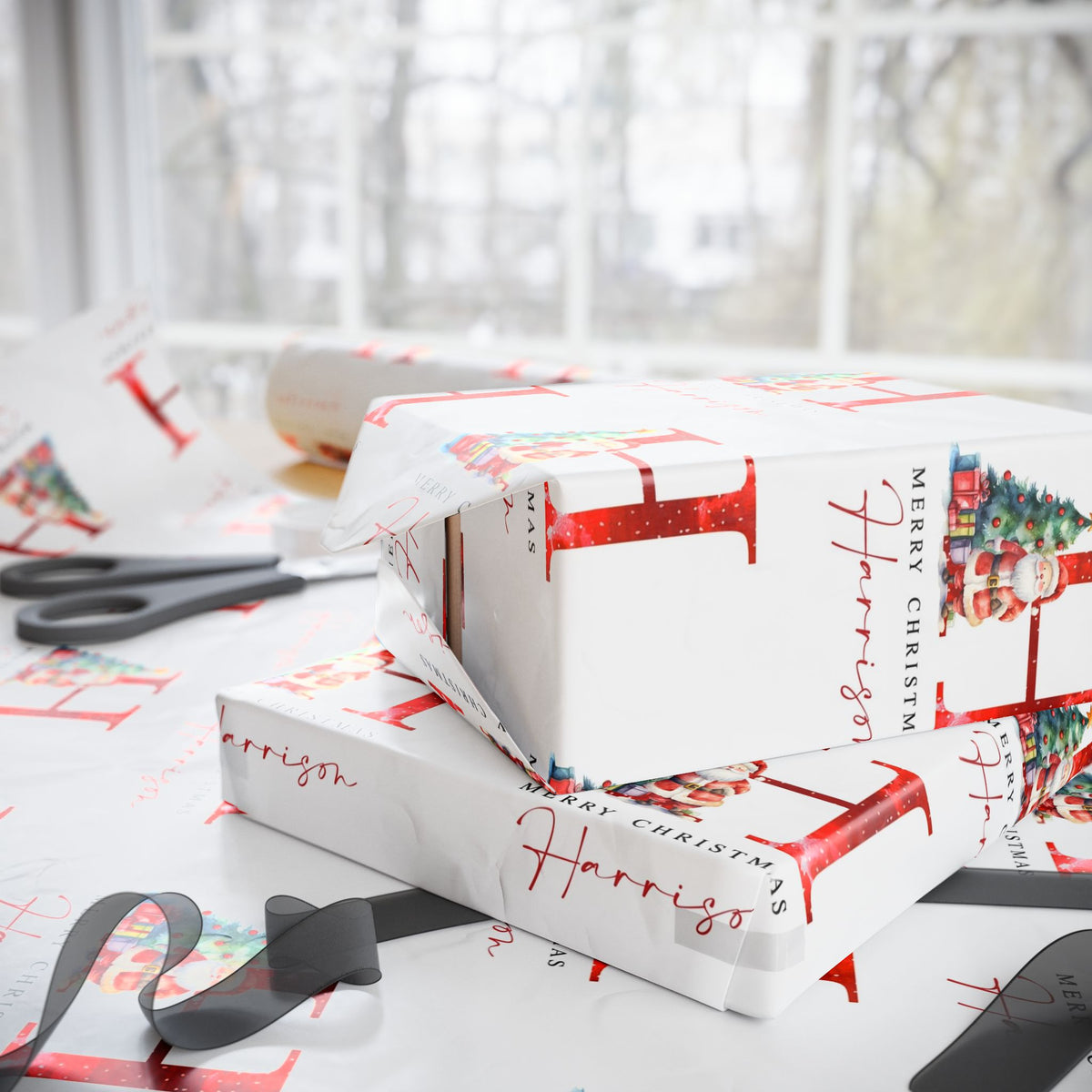 White Christmas themed wrapping paper with red script and holiday illustrations, shown wrapped around gift boxes on a table near a window. Scissors and ribbon are visible in the scene.