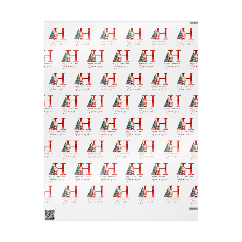 A sheet of wrapping paper featuring a repeating pattern of a large red letter H decorated with a Christmas tree, alongside the name 'Hannah' in red script, on a white background.