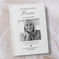 A personalised hardcover book titled 'Letters to My Mum in Heaven' with a black and white portrait photo of a woman on the cover, styled on a soft white fabric background.