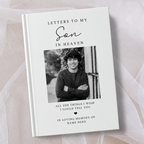 A personalised hardcover book titled 'Letters to My Son in Heaven' with a black and white photo of a young man on the cover, displayed on a soft beige fabric background.