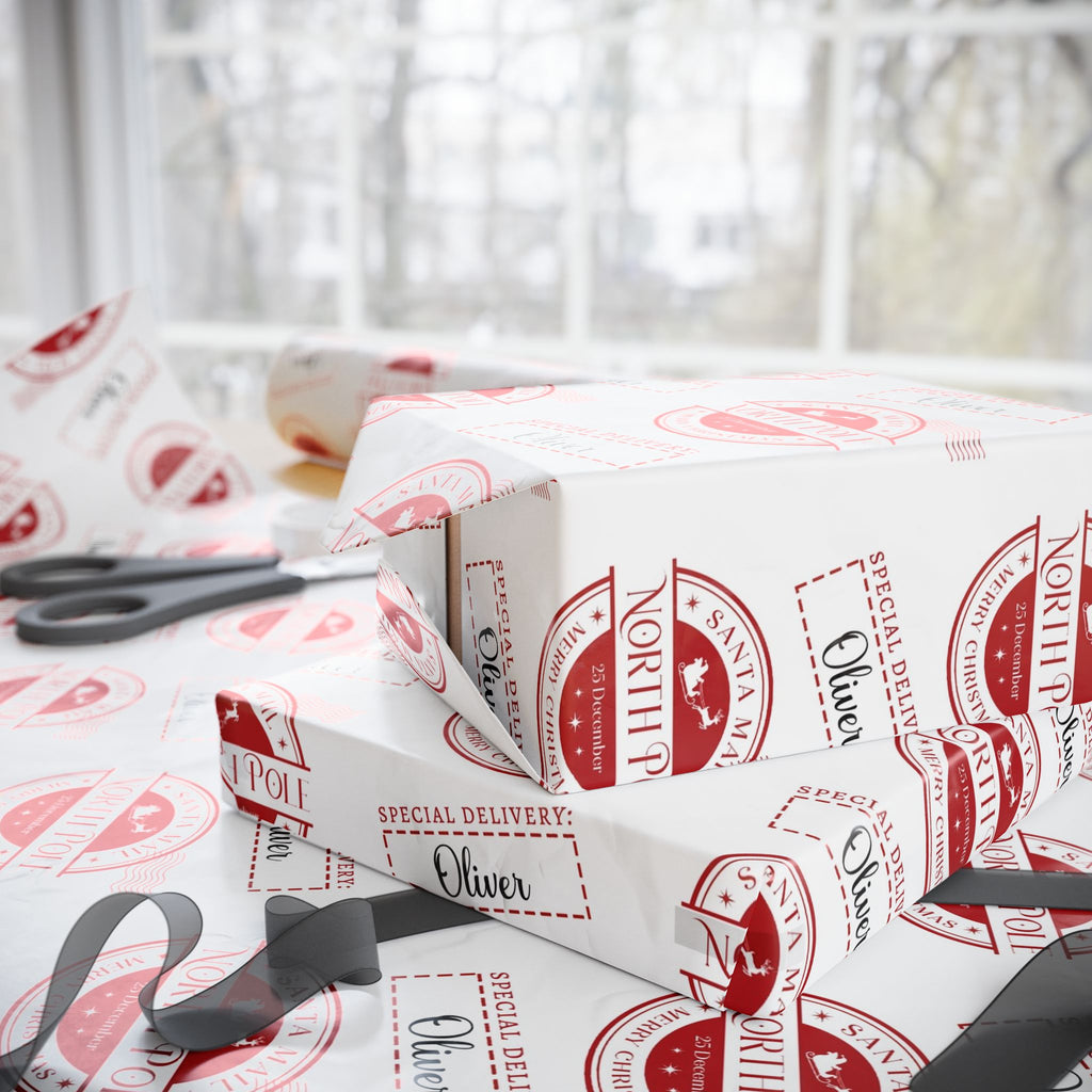 White wrapping paper with a red vintage Santa Claus stamp pattern, shown wrapped around gift boxes on a windowsill with scissors nearby.