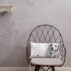 A rectangular personalised pet memorial throw pillow with a black and white photo of a golden retriever and printed text, resting on a black wire chair against a textured light grey wall.