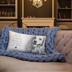A rectangular personalised pet memorial throw pillow featuring a black and white photo of a Golden Retriever and a touching memorial message, resting on a chunky blue knit blanket on a sofa in a cozy living room.