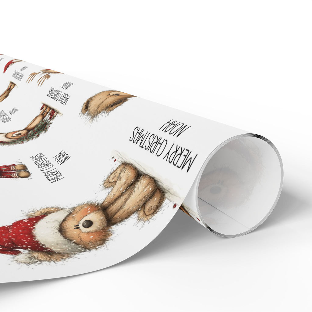 A roll of wrapping paper featuring a whimsical watercolour style print of teddy bears in holiday attire, with black text including 'MERRY CHRISTMAS' and 'NOAH', shown on a clean white background.