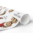 A roll of wrapping paper featuring a whimsical watercolour style print of teddy bears in holiday attire, with black text including 'MERRY CHRISTMAS' and 'NOAH', shown on a clean white background.