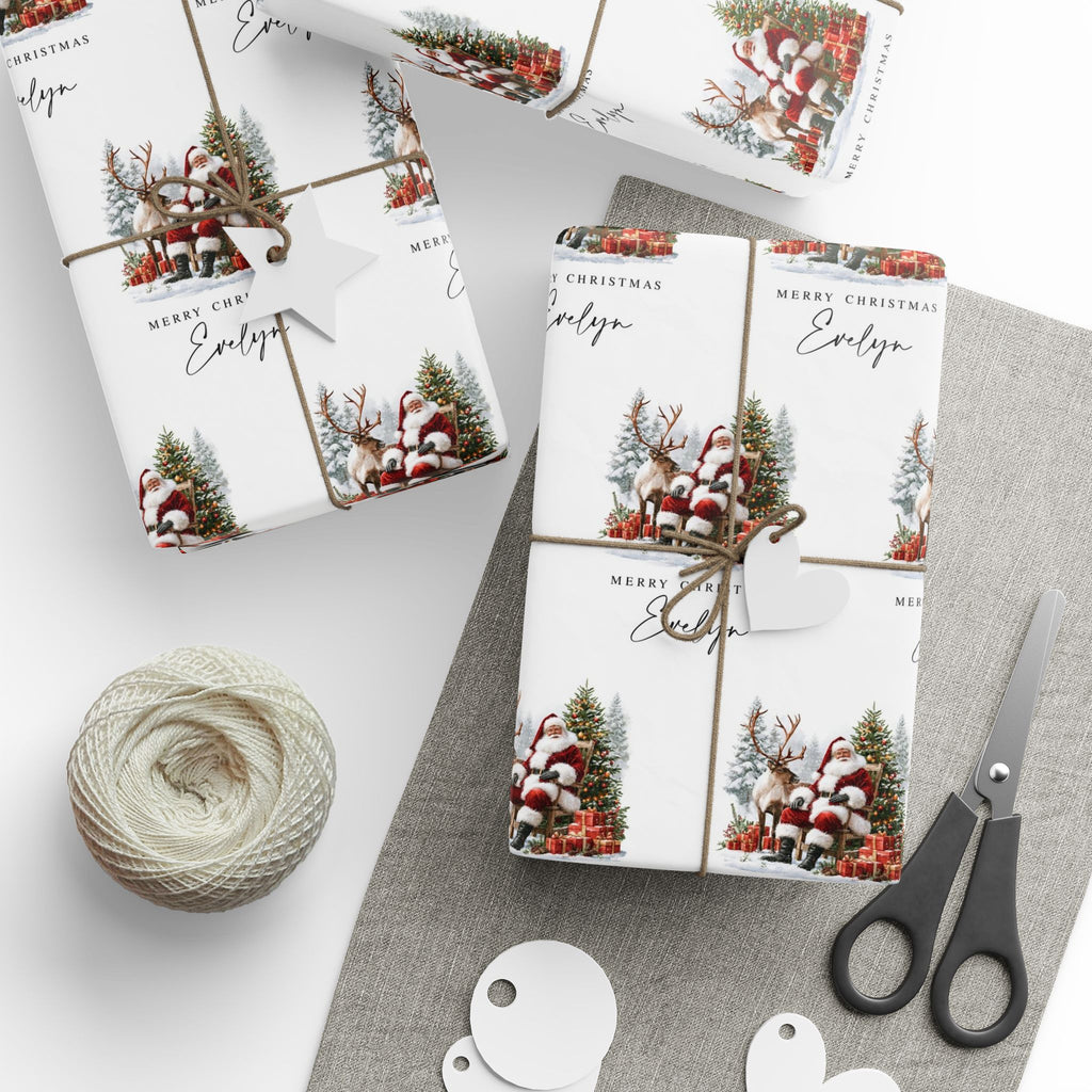 Three Christmas themed gift wraps wrapped around rectangular boxes, styled with twine, a heart-shaped tag, a ball of jute twine, scissors, and white round tags on a light grey surface.