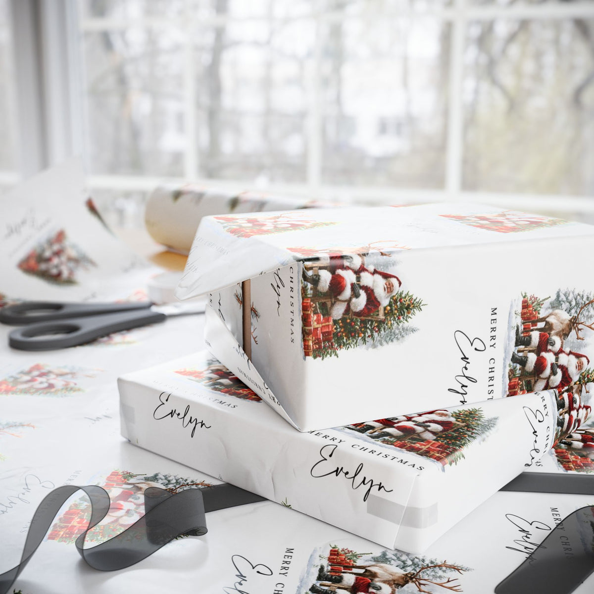 Christmas themed wrapping paper with pinecone and santa with reindeer illustrations, shown being used to wrap gift boxes on a table with scissors and ribbon near a bright window.