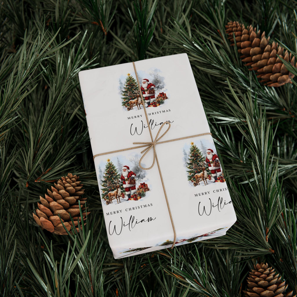 A wrapped gift box tied with twine, printed with Christmas illustrations and the text 'Merry Christmas William,' placed on green pine branches with pinecones.