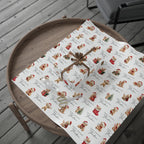 A roll of wrapping paper with a vintage teddy bear pattern, partially unrolled on a round wooden tray. The paper features a white background with a repeating print of brown Christmas teddy bears and Christmas outfits, alongside the word 'Merry Christmas' in cursive.